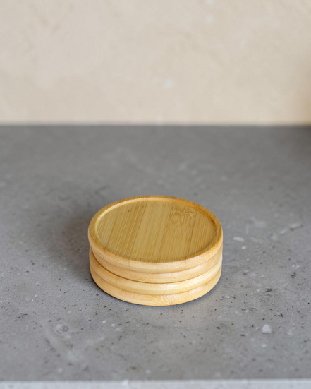 Ecohub NZ Essentials Bamboo Coaster Set of 4 - natural bamboo - stacked neatly on a textured grey concrete surface