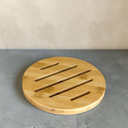Ecohub NZ Essentials Bamboo Trivet (18cm) - natural bamboo - resting flat on a textured grey concrete surface