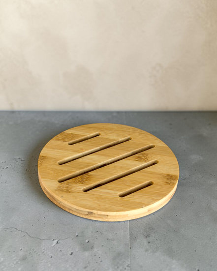 Ecohub NZ Essentials Bamboo Trivet (18cm) - natural bamboo - resting flat on a textured grey concrete surface