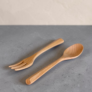 Ecohub NZ Entertainers Beech Cutlery Set of 2 - natural beech wood - fork and spoon resting on a grey concrete surface