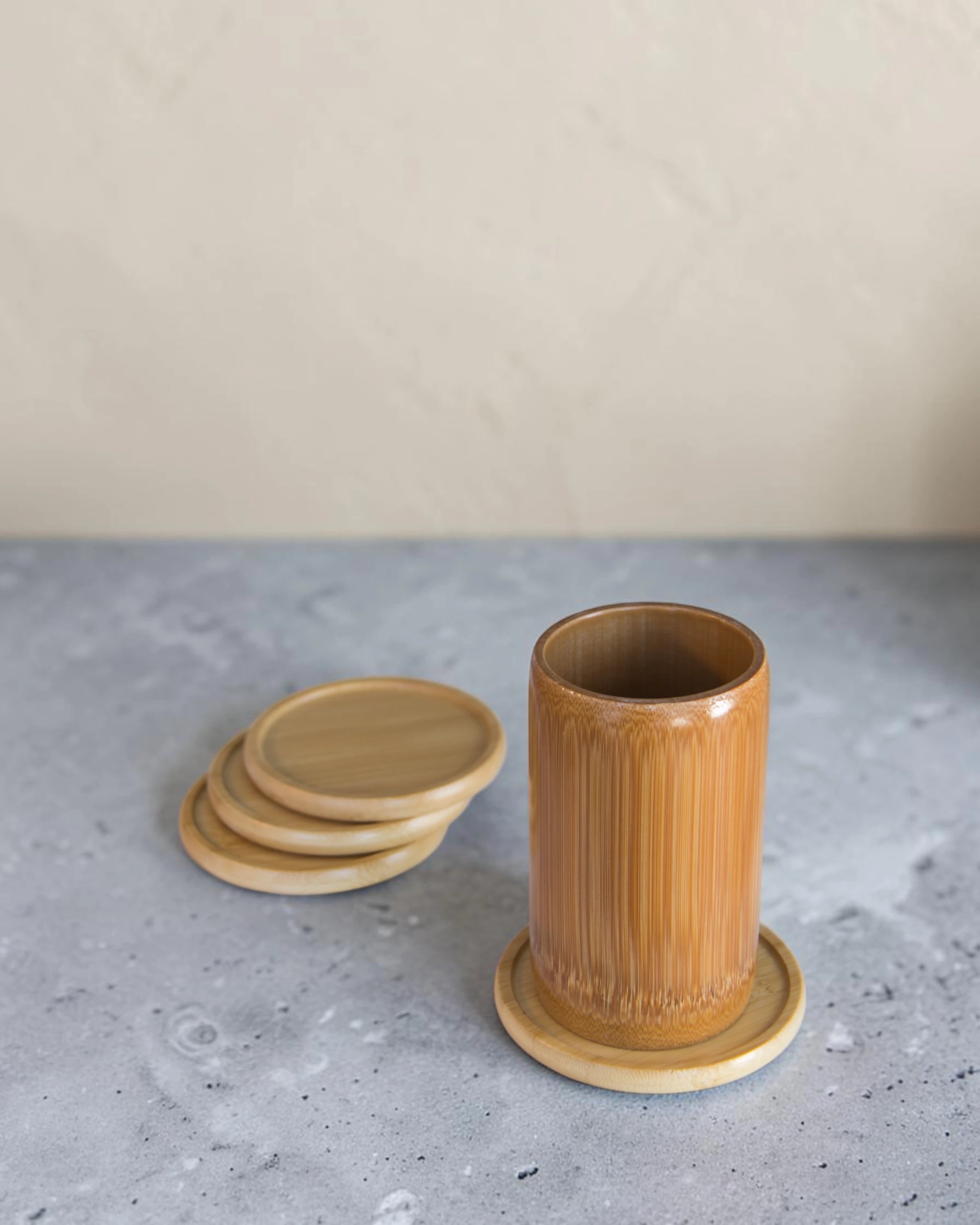 Ecohub NZ Essentials Bamboo Coaster Set of 4 - natural bamboo - one in use under a bamboo cup with others stacked nearby