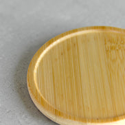 Ecohub NZ Essentials Bamboo Coaster Set of 4 - natural bamboo - close-up detail showing wood grain on grey concrete