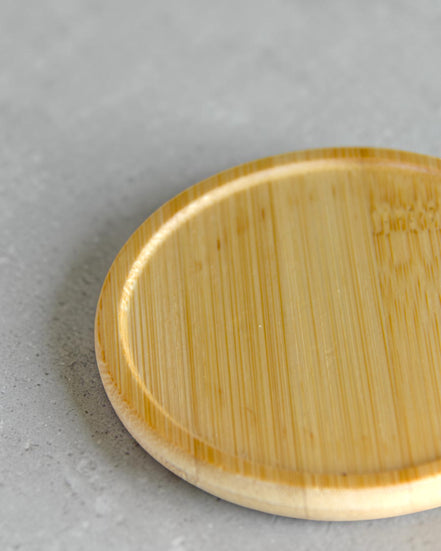 Ecohub NZ Essentials Bamboo Coaster Set of 4 - natural bamboo - close-up detail showing wood grain on grey concrete