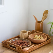 Ecohub NZ Artisans Rattan Rectangular Serving Tray (34cm) - natural rattan - holding bowls and a mug on a wood counter