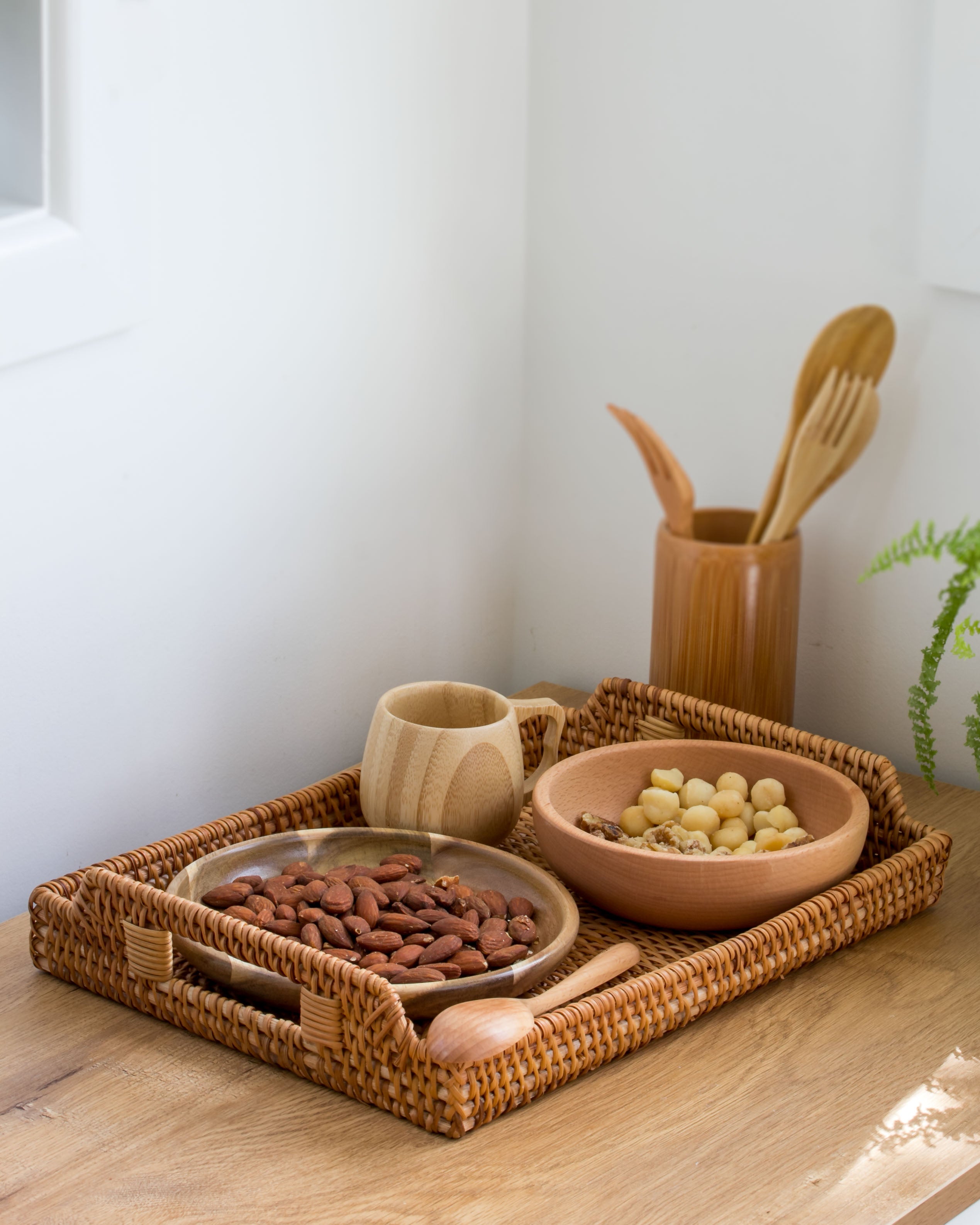 Ecohub NZ Artisans Rattan Rectangular Serving Tray (34cm) - natural rattan - holding bowls and a mug on a wood counter