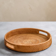 Ecohub NZ Artisans Rattan Round Serving Tray (35cm) - natural rattan - empty on a grey concrete surface