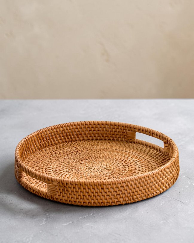 Ecohub NZ Artisans Rattan Round Serving Tray (35cm) - natural rattan - empty on a grey concrete surface