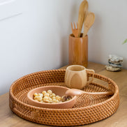 Ecohub NZ Artisans Rattan Round Serving Tray (35cm) - natural rattan - holding a snack bowl and mug on a wood counter