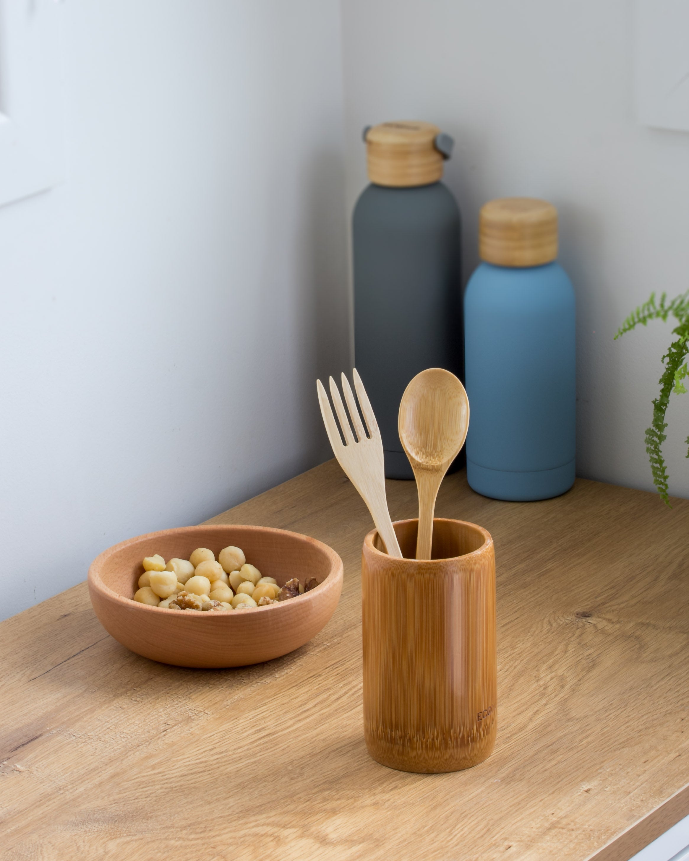 Ecohub NZ Essentials Bamboo Cutlery Set of 2 - natural bamboo - standing in a bamboo cup on a wooden kitchen counter