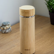 Ecohub NZ Essentials Bamboo Insulated Water Bottle (500ml) - natural bamboo and steel - standing on a wooden desk with plant