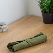 Ecohub NZ Essentials Bamboo Travel Cutlery Set of 7 - natural bamboo - rolled up in a green pouch on a wooden counter
