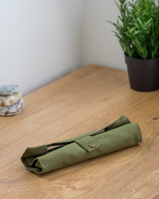 Ecohub NZ Essentials Bamboo Travel Cutlery Set of 7 - natural bamboo - rolled up in a green pouch on a wooden counter