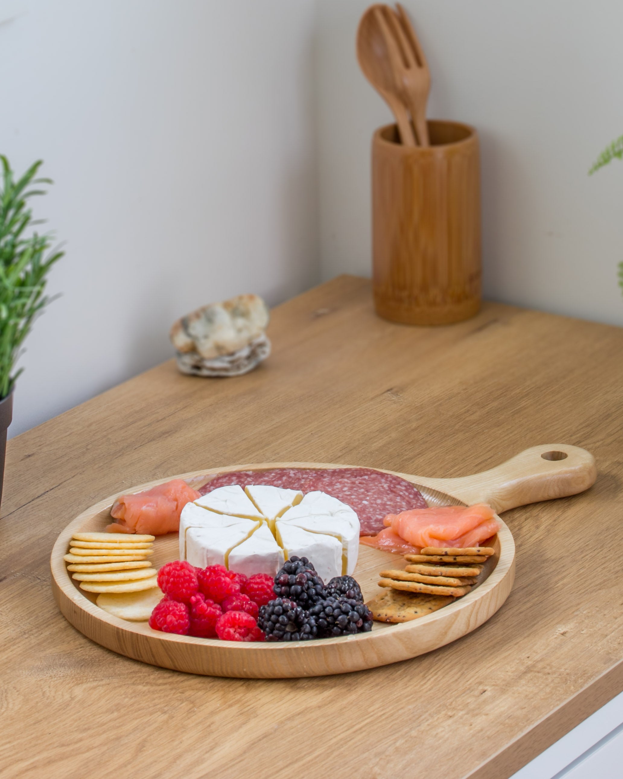 Ecohub NZ Entertainers Ash Round Paddle Board (35x25cm) - natural ash wood - serving charcuterie on a wood counter