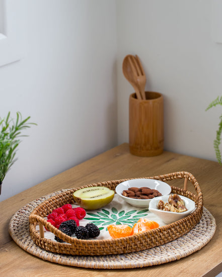 Ecohub NZ Artisans Rattan & Pearl Inlay Oval Serving Tray (31cm) - rattan and pearl - holding food on a wood counter