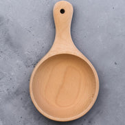 Ecohub NZ Entertainers Beech Handled Snack Bowl (15cm) - natural beech wood - top-down view empty on a textured grey concrete surface