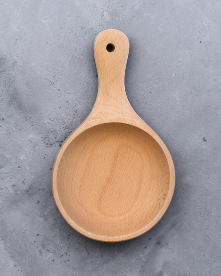 Ecohub NZ Entertainers Beech Handled Snack Bowl (15cm) - natural beech wood - top-down view empty on a textured grey concrete surface